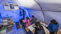Para guru sukarela mendirikan tiga tenda di kawasan pengungsian untuk sekolah darurat.  