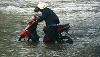 Pengendara mendorong sepeda motornya yang mogok saat menerobos banjir di Somba Opu, Kabupaten Gowa, Sulawesi Selatan. Sejumlah ruas jalan di daerah tersebut terendam banjir setelah diguyur hujan dengan intensitas tinggi dalam beberapa hari.