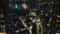 Seorang pria berjalan di pos pengamatan pusat perbelanjaan Costanera, saat kota terpantul di jendela gedung setelah matahari terbenam di Santiago, Chili. (AP Photo/Matias Delacroix)  