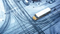 Sebuah bus sekolah melintasi persimpangan yang tertutup salju di Waukegan, Illinois. (AP Photo/Nam Y. Huh)  