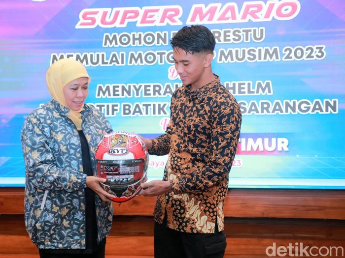 Gubernur Khofifah Indar Parawansa saat menerima helm dari pembalap Mario Aji