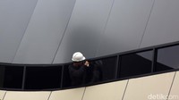 Pekerja tengah memasang jendela JPO.