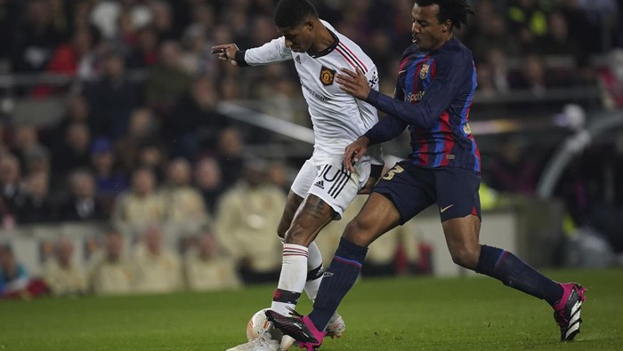 Manchester Uniteds Marcus Rashford, left, and Barcelonas Jules Kounde fight for the bal during the Europa League playoff first leg soccer match between Barcelona and Manchester United at the Camp Nou stadium in Barcelona, Spain, Thursday, Feb. 16, 2023. (AP Photo/Joan Mateu Parra)