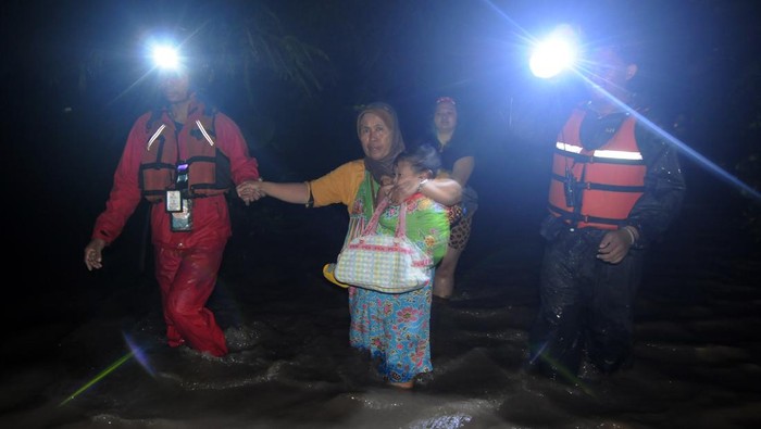 Klaten Masih Direndam Banjir, Warga Akhirnya Dievakuasi Warga menggendong seorang anak evakuasi karena banjir di Bener, Wonosari, Klaten, Jawa Tengah, Kamis (16/2/2023) malam. Curah hujan tinggi menyebabkan aliran Sungai Brambang meluap dan membanjiri perkampungan warga sehingga puluhan warga setempat dievakuasi ke Kantor Desa Bener. ANTARA FOTO/Aloysius Jarot Nugroho/aww.