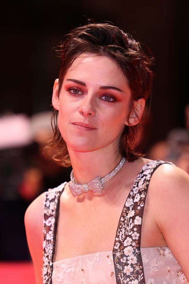 Kristen Stewart tampil dengan makeup ultra feminine di Berlinale. Wajahnya dirias dengan eyeshadow merah tua dan warna alis yang gelap. Foto: Getty Images/Franziska Krug