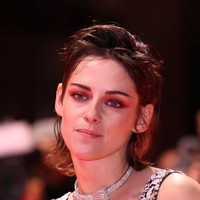 Kristen Stewart tampil dengan makeup ultra feminine di Berlinale. Wajahnya dirias dengan eyeshadow merah tua dan warna alis yang gelap. Foto: Getty Images/Franziska Krug