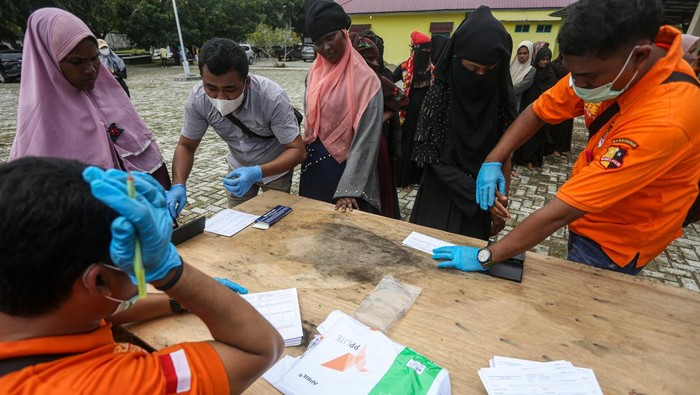 Melihat Proses Pendataan Imigran Etnis Rohingya di Aceh Besar Petugas Inafis dari Polresta Banda Aceh dan Polres Kabupaten Aceh Besar mengambil foto imigran etnis Rohingya di tempat penampungan sementara UPTD Dinas Sosial Aceh Rumoh Seujahtera Beujroh Meukaya Ladong, Aceh Besar, Aceh, Jumat (17/2/2023). Sebanyak 62 orang imigran etnis Rohingya yang terdampar di pantai Desa Lampanah Leugah, Aceh Besar pada Kamis (16/2/2023), dipindahkan ke tempat tempat penampungan sementara UPTD Dinas Sosial Aceh Rumoh Seujahtera Beujroh Meukaya Ladong, Aceh Besar, Aceh. ANTARA FOTO/Khalis Surry/Lmo/aww.