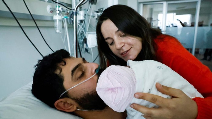 Mustafa Avci, 33, who was stuck under rubble for 261 hours, meets his daughter Almile for the first time and reunites with his wife Bilge, following the deadly earthquake, at a hospital in Mersin, Turkey February 17, 2023. Almile was born on the day of the earthquake. REUTERS/Clodagh Kilcoyne