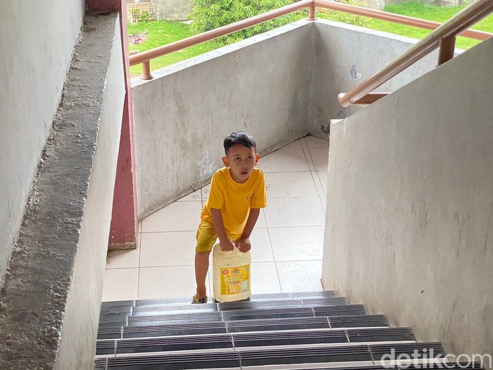 Muryati (46) dan putranya yang masih kecil mengangkut air dari lantai dasar sampai lantai 5 Rusun Marunda. 17 Februari 2023. (Devi Puspitasari/detikcom)