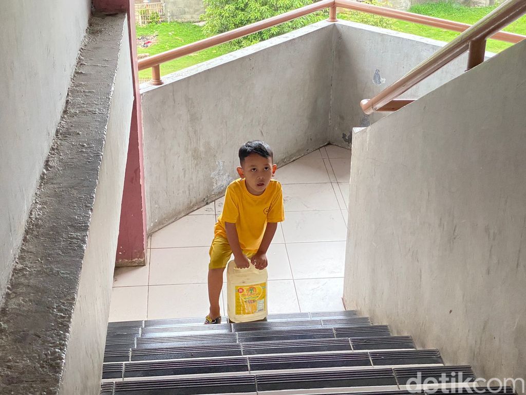 Muryati (46) dan putranya yang masih kecil mengangkut air dari lantai dasar sampai lantai 5 Rusun Marunda. 17 Februari 2023. (Devi Puspitasari/detikcom)