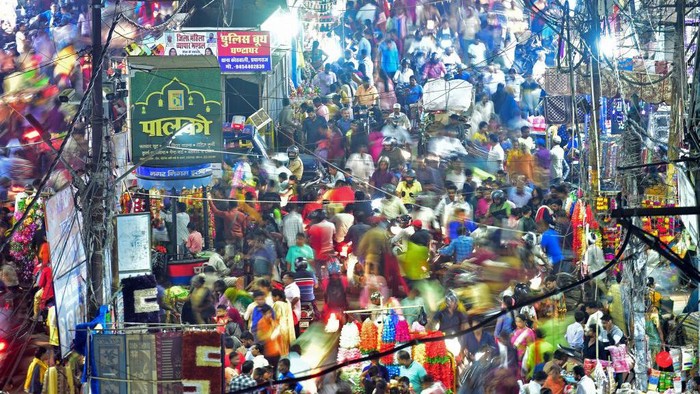 This picture taken on October 22, 2022 shows people walking through a market in Allahabad. - The global population will breach the symbolic level of 8 billion on November 15, according to the UN. The milestone comes as questions are increasingly being raised about the measures needed to adapt to global warming, as well as about how humanity consumes Earths resources. (Photo by Sanjay KANOJIA / AFP) (Photo by SANJAY KANOJIA/AFP via Getty Images)