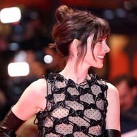 Sepasang anting berlian dari Bulgari menambah pesona kecantikan Anne Hathaway, yang memilih tatanan rambut sanggul tinggi berponi a la Audrey Hepburn. Foto: WireImage/Dominique Charriau