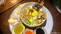 Bubur ayam tersebut disajikan menggunakan mangkuk material granit. Kemudian dilengkapi dengan aneka topping seperti cakwe, kacang kedelai, ayam, telur puyuh.