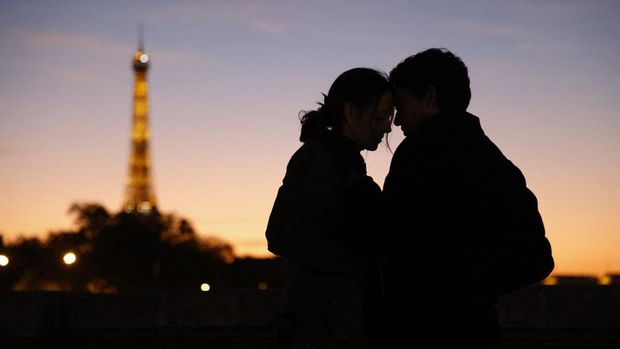 A couple kisses at sunset near The Eiffel Tower in Paris, on November 11, 2022. (Photo by Ludovic MARIN / AFP) (Photo by LUDOVIC MARIN/AFP via Getty Images)