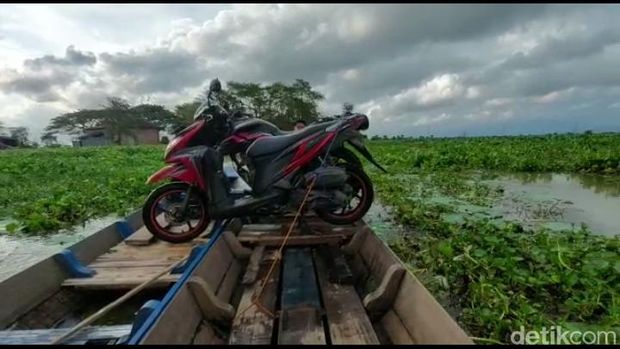 Ojek perahu di jalan alternatif Pati-Kudus di Desa Kasiyan, Kecamatan Sukolilo, Pati, Sabtu (18/2/2023).