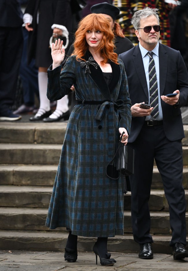 Christina Hendricks mengenakan coat dress motif kotak-kotak dengan lapel beludru hitam. Bros bentuk pita menjadi pelengkap gayanya. Foto: WireImage/Karwai Tang