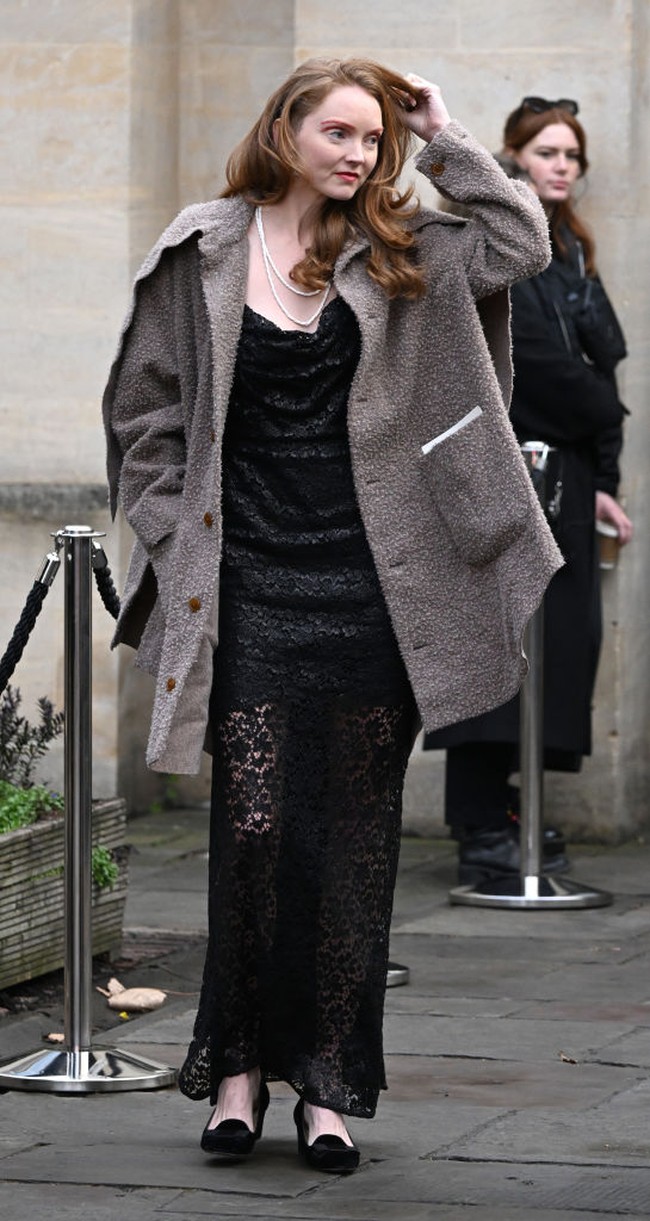 Model Lily Cole tampil mengenakan gaun lace dengan jaket fleece. Ia tampak melengkapi penampilannya dengan kalung mutiara. Foto: Getty Images/Jeff Spicer