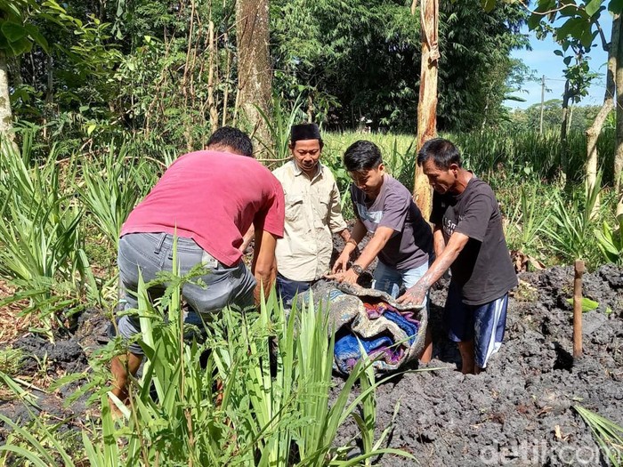 Polisi dibantu warga menggali sejumlah barang milik almarhum suami instruktur senam yang dikubur di belakang rumah