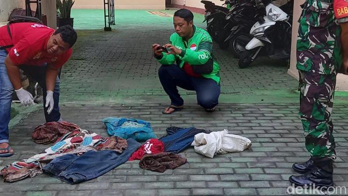 Polisi dibantu warga menggali sejumlah barang milik almarhum suami instruktur senam yang dikubur di belakang rumah