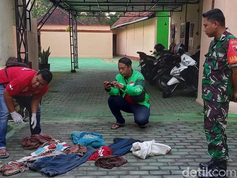 Polisi dibantu warga menggali sejumlah barang milik almarhum suami instruktur senam yang dikubur di belakang rumah