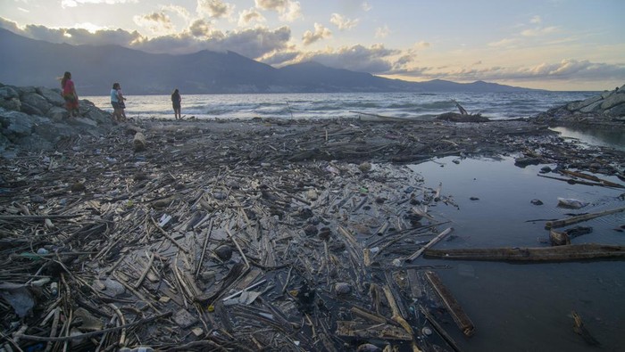 SAMPAH KIRIMAN KOTORI PANTAI TELUK PALU Sejumlah warga beraktivitas di pantai yang dipenuhi sampah kiriman di Pantai Teluk Palu, Palu, Sulawesi Tengah, Sabtu (18/2/2023). Sampah yang mengotori kawasan wisata pantai itu adalah kiriman dari Kalimantan akibat angin dan arus laut yang secara periodik mengalir dari Selat Makassar menuju teluk pada setiap musim angin barat. ANTARA FOTO/Basri Marzuki/hp.