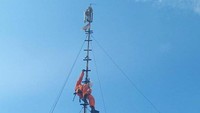 Petugas memanjat tiang pemancar wi-fi untuk mengevakuasi ular yang nangkring di atas tiang (Foto: Istimewa/Command Center 112)