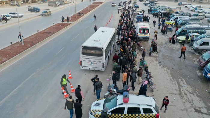 An aerial picture shows Syrian refugees living in Turkey waiting to take a bus through the northern Bab al-Hawa border crossing, on February 17, 2023, as they return to Syria in the aftermath of a deadly earthquake. - Turkey this week allowed Syrians under its protection who hold ID cards from one of the quake-hit provinces to leave for between three and six months, a rule change designed to reunite families on both sides of the border hit by the February 6 disaster, which has killed more than 41,000 people and displaced millions across both countries. (Photo by Omar HAJ KADOUR / AFP) (Photo by OMAR HAJ KADOUR/AFP via Getty Images)
