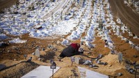 Seorang wanita menangis di atas kuburan putra dan putrinya, yang tewas saat gempa di pemakaman Sehir di Malatya, Turki. Dilansir dari AFP, sampai dengan Sabtu (18/2/2023), korban tewas akibat gempa dahsyat itu lebih dari 44.000. AP/Francisco Seco 