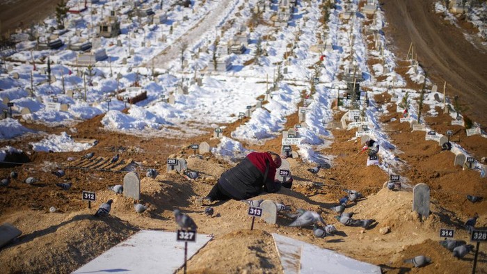 A woman cries over the graves of her son and daughter, killed during the earthquake at Sehir cemetery in Malatya, Turkey, Sunday, Feb. 12, 2023. Five days after two powerful earthquakes hours apart caused scores of buildings to collapse, killing thousands of people and leaving millions homeless, rescuers were still pulling unlikely survivors from the ruins. (AP Photo/Francisco Seco)