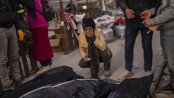Korban Tewas Akibat Gempa Turki dan Suriah Tembus 44 Ribu Jiwa A family mourns next to bodies of relatives that were pulled from the rubble of a destroyed building in Antakya, southeastern Turkey, Wednesday, Feb. 15, 2023. The earthquakes that killed more than 39,000 people in southern Turkey and northern Syria is producing more grieving and suffering along with extraordinary rescues and appeals for aid. (AP Photo/Bernat Armangue)
