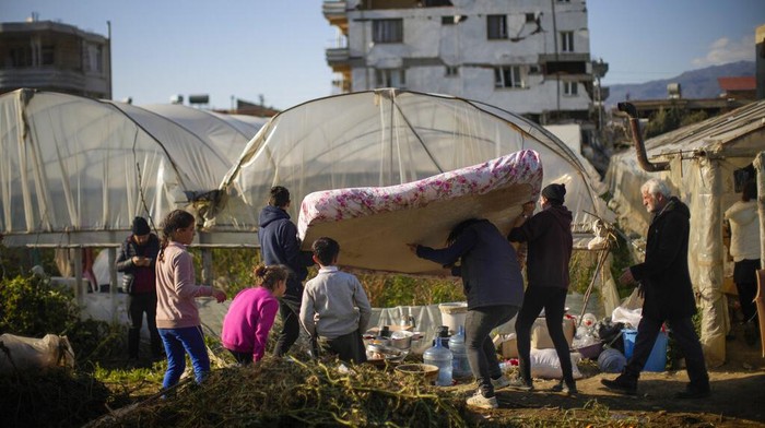 FILE -  Local residents bring a mattress to a greenhouse where they shelter after the earthquake in Samandag, southern Turkey, on Feb. 16, 2023. Hundreds of thousands of people are seeking shelter after the Feb. 6 earthquake in southern Turkey left homes unlivable. Many survivors have been unable to find tents or containers dispatched to the region by the government and aid agencies, Instead they have sought refuge in any structure that can protect them from the winter conditions, including greenhouses, rail carriages and factories. (AP Photo/Francisco Seco)