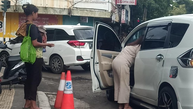 Aksi pengemis meminta-minta di salah satu toko di wilayah Kecamatan Negara, Jembrana, Bali, Minggu (19/2/2023).
