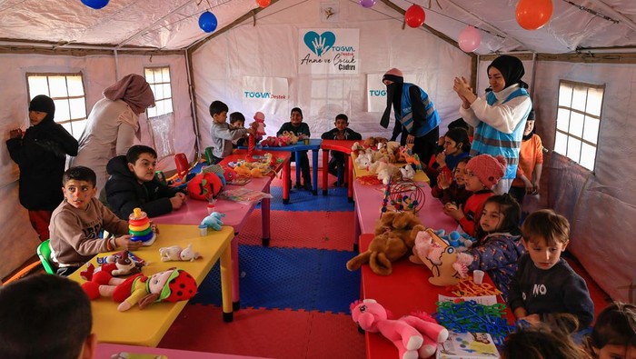 Potret Trauma Healing Anak-anak Korban Gempa Turki di Pengungsian Volunteers sing with children during an activity to entertain and support the mental health of children affected by the deadly earthquake, at a camp for survivors, in Adiyaman, Turkey, February 18, 2023. REUTERS/Thaier Al-Sudani