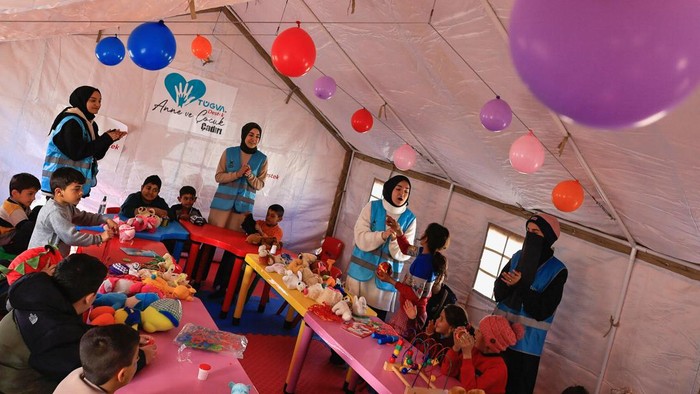 Volunteers sing with children during an activity to entertain and support the mental health of children affected by the deadly earthquake, at a camp for survivors, in Adiyaman, Turkey, February 18, 2023. REUTERS/Thaier Al-Sudani