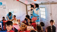 Balon warna-warni digantung di atas tenda di sebuah kamp kemanusiaan di Adiyaman, Turki, di mana sejumlah anak korban selamat gempa bernyanyi dan bermain bersama para relawan. 