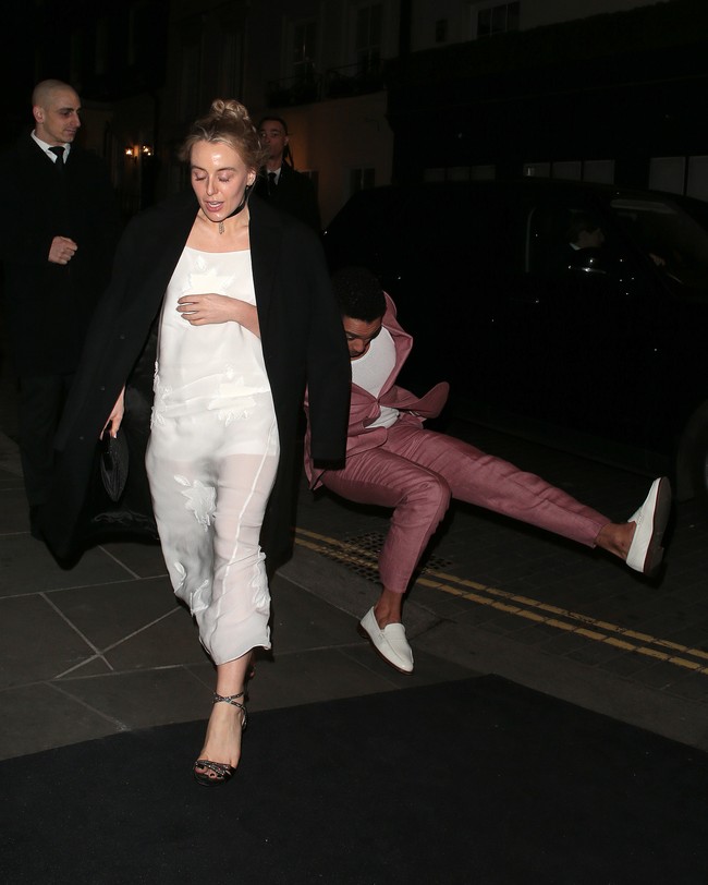 Rege-Jean Page yang sudah tampil maksimal dengan setelan pink dan loafers putih yang senada dengan kausnya sampai terjatuh dalam posisi duduk. (Foto: Neil Mockford / Ricky Vigil M/GC Images)