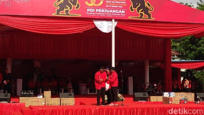 Sekjen PDIP Hasto Kristiyanto menyematkan jaket partai ke Menkop Teten Masduki. (Matius Alfons/detikcom)