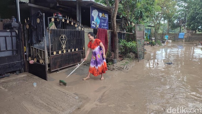 Warga di Perumahan Dinar Indah Semarang membersihkan tumpukan lumpur, Minggu (19/2/2023). Tumpukan lumpur ini kembali menggenang setelah banjir susulan sore ini.