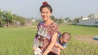 Penampilan Vicky Shu di tengah sawah bersama anaknya yang digendong di belakang. Foto: Instagram