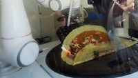 Pelanggan dapat menyaksikan langsung aksi memasak dari si koki robot.