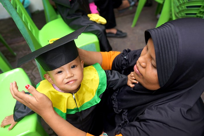 Ketua Tim Penggerak PKK Kabupaten Gorontalo Fory Naway (kiri) mewisuda balita lengkap imunisasi di Desa Dulomo, Kabupaten Gorontalo, Gorontalo, Senin (20/2/2023). Wisuda balita merupakan program Pemerintah Kabupaten Gorontalo untuk meningkatkan jumlah kepesertaan bayi yang diimuniasi sebagai upaya pencegahan tengkes (stunting) serta menjadi salah satu syarat untuk masuk Pendidikan Anak Usia Dini (PAUD). ANTARA FOTO/Adiwinata Solihin/rwa.
