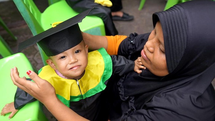 Ketua Tim Penggerak PKK Kabupaten Gorontalo Fory Naway (kiri) mewisuda balita lengkap imunisasi di Desa Dulomo, Kabupaten Gorontalo, Gorontalo, Senin (20/2/2023). Wisuda balita merupakan program Pemerintah Kabupaten Gorontalo untuk meningkatkan jumlah kepesertaan bayi yang diimuniasi sebagai upaya pencegahan tengkes (stunting) serta menjadi salah satu syarat untuk masuk Pendidikan Anak Usia Dini (PAUD). ANTARA FOTO/Adiwinata Solihin/rwa.
