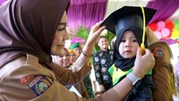 Ketua Tim Penggerak PKK Kabupaten Gorontalo Fory Naway (kiri) mewisuda balita lengkap imunisasi di Desa Dulomo, Kabupaten Gorontalo, Gorontalo, Senin (20/2/2023).