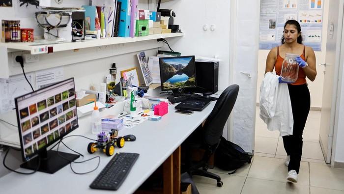 Ilmuwan Israel Bikin Robot Pengendus Penyakit dengan Antena Belalang A scientist holds a newly-developed robot that, when fitted with a locust antenna, can detect and identify odours, at the Tel Aviv University, in Tel Aviv, Israel January 25, 2023. REUTERS/Amir Cohen