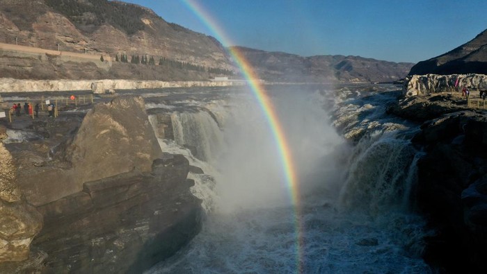 Indahnya Semburat Pelangi Terbit di Atas Air Terjun di China LINFEN, CHINA - FEBRUARY 19: A rainbow arches over the Hukou Waterfall in winter on February 19, 2023 in Linfen, Shanxi Province of China. (Photo by Lyu Guiming/VCG via Getty Images)