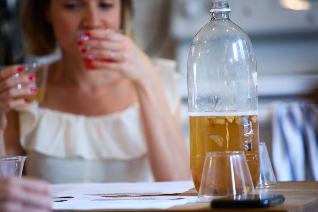 A woman drinks Kombucha as she attends a workshop by Fermentationist Cheryl Paswater in the Brooklyn borough of New York City, on June 29, 2019. - The recent kombucha craze has been fermenting for decades. All natural, low sugar, and packed with supposed health benefits, the once-niche drink has invaded grocery stores, supermarkets and cafes. Sales of the drink reached $412 million in the United States for 2018, according to Nielsen data, a 42 percent increase from the year before.From the corner store to American retail giant Walmart, most shops sell kombucha. Some offer up to 10 different brands of the drink, whose exact origins are unknown. (Photo by Kena Betancur / AFP)        (Photo credit should read KENA BETANCUR/AFP via Getty Images)