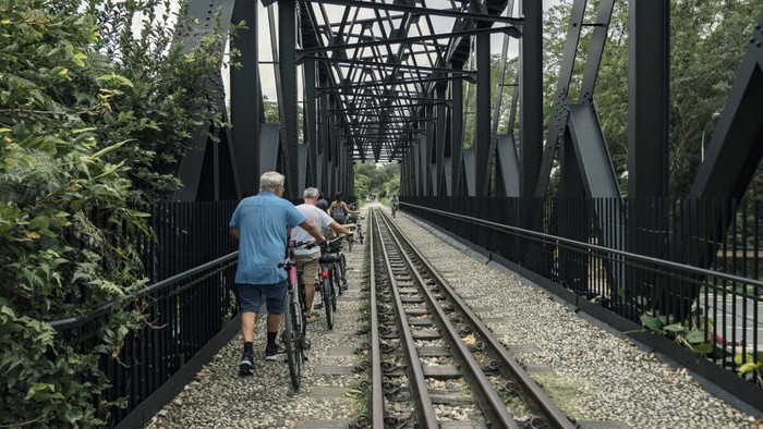 Cyclists on the Bukit Timah truss bridge on the Rail Corridor in Singapore, on Monday, Jan. 2, 2023. A former railway line running through the heart of Singapore has turned into one of its biggest conservation success stories, marking a departure from the more manicured approach to nature that the city-state is known for. Photographer: Lauryn Ishak/Bloomberg via Getty Images
