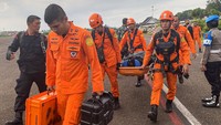 Personel Basarnas Jambi berjalan menuju helikopter MI171 milik APP Sinar Mas di Bandara Sultan Thaha lama, Jambi, Minggu (19/2/2023).