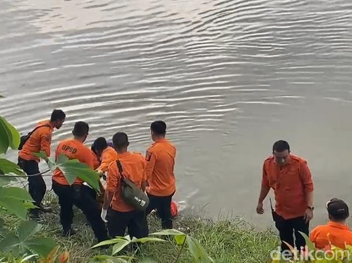 Petugas evakuasi jasad Mr.X di dekat Pintu Air Jagir Wonokromo Surabaya.
