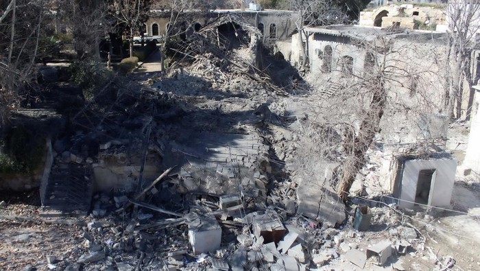 Police officers stand on the rubble of a damaged building at the site of a rocket attack, in central Damascus' Kafr Sousa neighborhood, Syria, February 19, 2023. REUTERS/Firas Makdesi